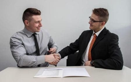 Two professionals shaking hands in agreement, symbolizing a successful RFP response.